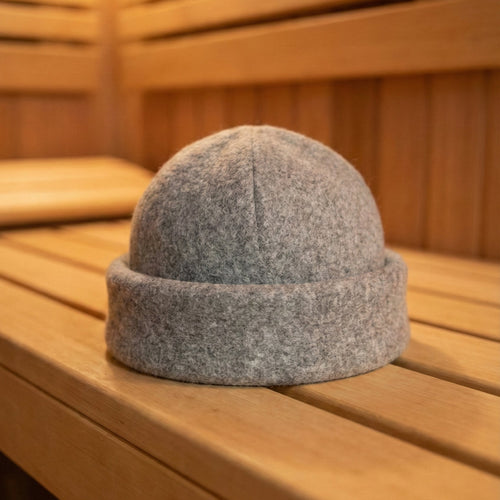 Gray beanie on a wooden bench in a sauna setting